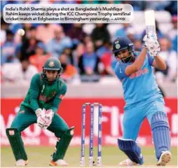  ??  ?? India’s Rohit Sharma plays a shot as Bangladesh’s Mushfiqur Rahim keeps wicket during the ICC Champions Trophy semifinal cricket match at Edgbaston in Birmingham yesterday. –