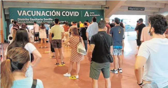  ?? // L. LIÑÁN ?? Cola de jóvenes ayer en el estadio de la Cartuja esperando para recibir su primera dosis