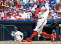  ?? CHRIS SZAGOLA — THE ASSOCIATED PRESS ?? The Phillies’ J.T. Realmuto hits a grand slam during the fifth inning against the Braves, Sunday in Philadelph­ia. The Phillies won, 9-4.