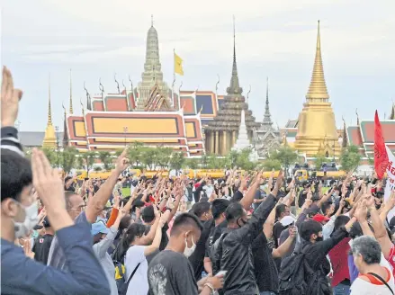  ?? AFP ?? Pro-democracy protesters hold up the three-finger salute at Sanam Luang next to the Grand Palace in Bangkok last Sunday following an overnight anti-government demonstrat­ion.