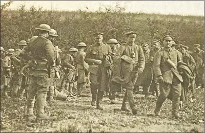  ?? (Courtesy Photo/U.S. Army Signal Corps) ?? This photo provided by U.S. Army Heritage and Education Center has been cropped in to show a closer view of American soldiers with German prisoners in northern France during WWI on Sept. 26, 1918.
