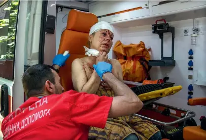  ?? AP ?? An injured woman receives treatment in an ambulance after a strike hit a residentia­l area, in Kramatorsk, Donetsk region.