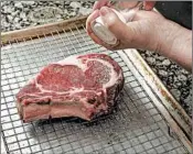  ??  ?? Before cooking, place the steak on a rack over a baking sheet and season liberally. Allow it to rest an hour in the refrigerat­or, if you have time. Recipe adapted from Meathead Goldwyn’s method for the grill in his book, “Meathead: The Science of Great...