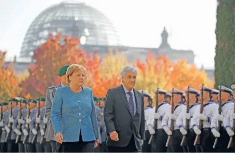  ?? (AFP) ?? German Chancellor Angela Merkel (left) and Chilean President Sebastian Pinera review a guard of honour at the Chanceller­y in Berlin on Wednesday