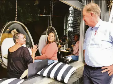  ?? Dan Haar/Hearst Connecticu­t Media ?? Gov. Ned Lamont joked Friday afternoon with two customers at The Place 2 Be restaurant in West Hartford. Sandra Cohen, left, from Berlin, said she was a supporter. Sandra Rivera is from Rhode Island.