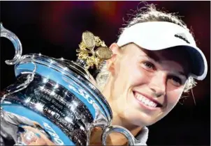  ?? AFP ?? Caroline Wozniacki poses with the trophy after beating Simona Halep in the Australian Open women’s final in Melbourne on Saturday.
