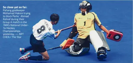  ?? — ART CHEN / The Star ?? So close yet so far: Pahang goalkeeper Mohamad Hakimi trying to block Perlis’ Ahmad Ashraf during their Group A match in the 1MAS National Under14 Hockey Championsh­ips yesterday.