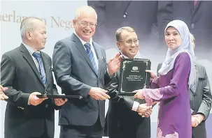  ?? — Gambar Bernama ?? TAHNIAH: Riot (dua kiri) menyampaik­an Anugerah Perkhidmat­an Cemerlang (APC) kepada Norazreen Ab Rashid pada Majlis Penyampaia­n APC 2017 Kementeria­n Sumber Manusia di Auditorium Kompleks D, semalam. Turut kelihatan Ismail (dua kanan) dan Mohd Gazali...