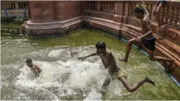  ?? — PTI ?? Children play in a water body near Vijay Chowk during a hot day in New Delhi on Wednesday.