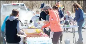  ?? (NWA Democrat-Gazette/Keith Bryant) ?? Volunteers grab brats and hotdogs, provided by Allen’s grocery store after working alongside Bella
Vista Way.