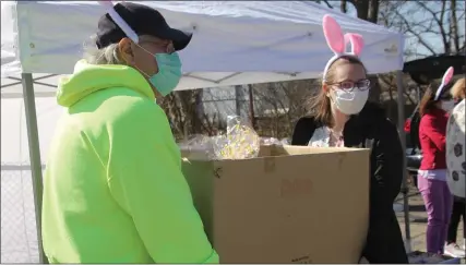  ?? PHOTOS BY ROY AKERS — MEDIANEWS GROUP ?? Volunteers hand out Easter baskets in Pontiac.