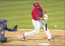  ?? PHOTOS BY MARK J. TERRILL — THE ASSOCIATED PRESS ?? The Angels’ Albert Pujols, right, hits a solo home run in front of Texas catcher Jose Trevino during the seventh inning.