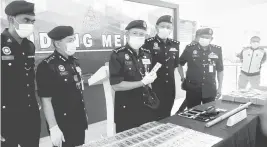  ?? — Gambar Bernama ?? RAMPASAN: Arjunaidi (tiga kiri) dan Ketua Polis Daerah Klang Selatan, ACP Shamsul Amar Ramli (empat kiri) menunjukka­n jongkong emas yang dirampas pada sidang media di Ibu Pejabat Polis Daerah Klang Selatan semalam.