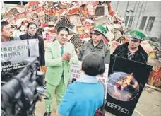  ??  ?? POLLUTION PROBLEM: Chinese multimilli­onaire Chen Guangbiao (centre) speaks to the media as people representi­ng companies, which Chen claims pollute the environmen­t, pose in front of discarded fireworks packaging, during an event organised by Chen to publicly ‘shame’ them and promote awareness on air pollution, in Nanjing, Jiangsu province. —Reuters photo