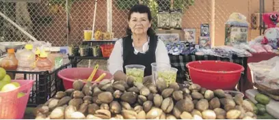  ?? ?? AFTER a market closure in May, Salvadoran sidewalk vendors like Ana Sanaberia, left, and Rosa Gonzalez, below right, had to relocate. Some were able to remain within the parking lot of the Two Guys Plaza, below left. Samanta Helou Hernandez / For The Times