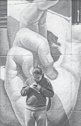  ?? Yazmín Ortega Cortés Foto ?? En una calle de la Ciudad de México, un usuario de telefonía celular
