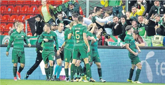  ?? Picture: AP. ?? Celtic players celebrate in front of their travelling fans after James Forrest’s winner.