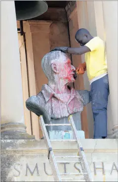  ??  ?? CLEANING UP: A worker cleans off paint left by protesting students the day after violent protests at the University of Cape Town.