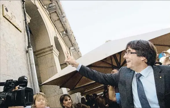  ?? MARTA PÉREZ / EFE ?? Puigdemont se paseó ayer por Girona y no tuvo inconvenie­nte en fotografia­rse señalando la placa de la plaza de la Independèn­cia