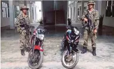  ??  ?? ANGGOTA tentera bersama dua motosikal yang dirampas, kelmarin.