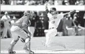  ?? Jason O. Watson Getty I mages ?? BEN ZOBRIST of the Athletics slides past Carlos Perez of the Angels to score in the sixth inning.