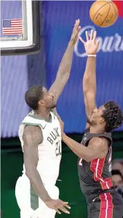  ?? — AP ?? Marvin Williams ( left) of the Milwaukee Bucks defends as Jimmy Butler of Miami Heat takes a shot during the second half of an NBA basketball conference semifinal playoff game in Lake Buena Vista, Florida, on Monday.