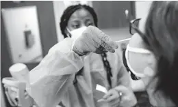  ?? STEPHEN M. KATZ/STAFF FILE ?? Midrenne Sampson, radiology technologi­st with Velocity Urgent Care in Virginia Beach, performs an antigen test on a patient last October.