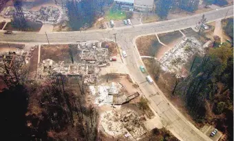  ?? GREG SORBER/JOURNAL ?? Under smoke-filled skies, the burned ruins of houses line the streets where the Cerro Grande Fire hit the northweste­rn edge of Los Alamos in 2000.