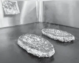  ?? RICHA NAIDU • REUTERS ?? A plant-based Impossible Pork patty is cooked at the Impossible Foods headquarte­rs in Silicon Valley in San Francisco.