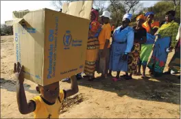  ?? TSVANGIRAY­I MUKWAZHI — THE ASSOCIATED PRESS FILE ?? On Sept. 9, 2015, a child carries a parcel from the United Nations World Food Program in Mwenezi, Zimbabwe. The WFP has won the 2020 Nobel Peace Prize for its efforts to combat hunger and food insecurity around the globe.