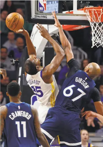  ?? Jim Mone / Associated Press ?? The Timberwolv­es’ Taj Gibson breaks up a scoring attempt by Warriors forward Kevin Durant in the first half. With Stephen Curry out, Durant had 39 points and 12 rebounds in 39 minutes.