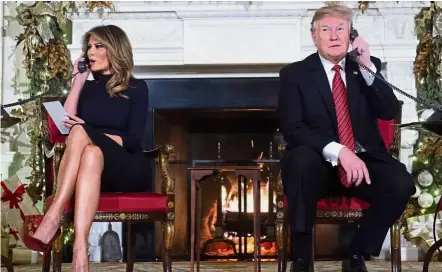  ??  ?? Season’s greetings: The Trumps answering calls from people calling into the Norad Santa tracker phone line in the State Dining Room of the White House in Washington, DC. — AFP