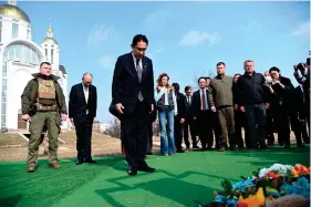  ?? (Ukrainian Foreign Ministry Press Office via AP) ?? Japanese Prime Minister Fumio Kishida, centre, offers prayers, at a church in Bucha, a town outside Kyiv that became a symbol of Russian atrocities against civilians, in Ukraine, Tuesday, March 21, 2023.
