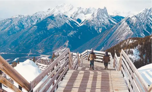  ?? Photos by Rachel Walker, for The Washington Post ?? Henry and Silas Walker stroll along the Sulphur Mountain Boardwalk, which takes visitors on a ridgeline walk and delivers 360-degree views of the Bow River Valley.