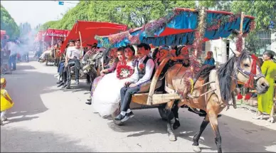  ?? YUAN HUANHUAN / FOR CHINA DAILY ?? Thirteen Uygur newlyweds enjoy a carriage cruise as part of a group wedding in Kuche county in the Xinjiang Uygur autonomous region on Tuesday.