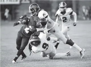  ?? PHOTOS BY MARK GILLILAND ?? Howard’s Tyjan Pulliam gets tackled by Tyner’s Jaylen Bowens and Caevon Lee during Friday’s game.