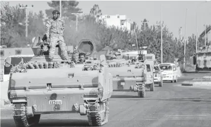  ?? REUTERS ?? Members of Syrian National Army, known as Free Syrian Army, drive in an armoured vehicle in the Turkish border town of Ceylanpina­r in Sanliurfa province, Turkey on Friday.