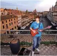  ??  ?? Jacopo Mastrangel­o plays the guitar from his terrace overlookin­g Piazza Navona in Rome during a lockdown in Italy to curb the spread of the COVID-19 pandemic, caused by the new coronaviru­s.—AFP