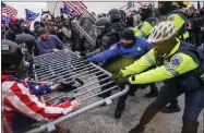  ??  ?? Trump supporters tear down a police barrier.