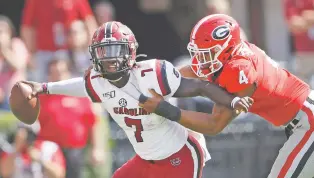  ?? JOHN BAZEMORE/ASSOCIATED PRESS ?? South Carolina quarterbac­k Dakereon Joyner is tackled by Georgia’s Nolan Smith on Saturday in Athens, Ga. South Carolina beat No. 3 Georgia 20-17 in two overtimes.