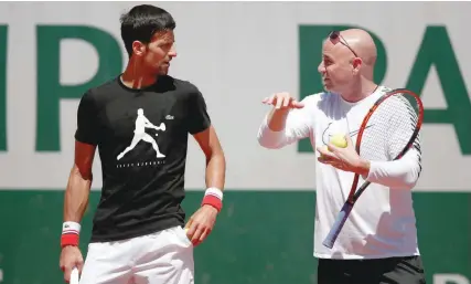  ?? — Reuters ?? Novak Djokovic and his coach Andre Agassi during a training session at Roland Garros in Paris on Thursday.