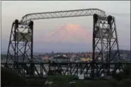  ?? TED S. WARREN — THE ASSOCIATED PRESS ?? Mount Rainier is seen at dusk and framed by the Murray Morgan Bridge in downtown Tacoma, Wash. The eruption of the Kilauea volcano in Hawaii has geologic experts along the West Coast warily eyeing the volcanic peaks in Washington, Oregon and...