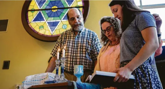  ?? Photos by Godofredo A. Vasquez / Staff photograph­er ?? Rabbi Deborah Schloss, center, is joined by her husband, Eljay Waldman, and her daughter, Priya Schloss Fink, at the beginning of a service at Temple Beth Tikvah.