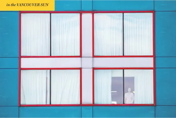  ?? CARLOS OSORIO / REUTERS ?? A person peers out of a window at a hotel near Toronto's Pearson airport, part of the new quarantine requiremen­t for incoming air travellers to Canada.