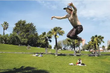  ?? Santiago Mejia / The Chronicle ?? Cyrus Kayhan walks on a slack line on a warm day at Dolores Park in San Francisco. Kayhan is visiting the city and soaking in the sunshine while on spring break from Santa Barbara.