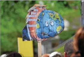  ?? MARIAN DENNIS — DIGITAL FIRST MEDIA ?? An activist in Pottstown holds up a sign at the Pottstown Climate March Saturday that reads, “We can’t ignore climate change.” The sign was one among a sea of others that expressed concerns over the current administra­tion’s views on environmen­tal policy.