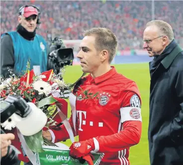 ?? FOTO: IMAGO ?? Blumen für den Kapitän: Philipp Lahm und Vorstandsc­hef Karl-Heinz Rummenigge (r.) vor dem Wolfsburg-Spiel.