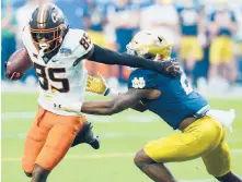  ?? ROSS D. FRANKLIN/AP ?? Oklahoma State wide receiver Jaden Bray, left, eludes Notre Dame safety DJ Brown during the Fiesta Bowl on Saturday in Glendale, Ariz.