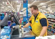  ?? NWA Democrat-Gazette/BEN GOFF • @NWABENGOFF ?? Jonathan Cousins, Wal-Mart employee, rings up a customer Thursday at the supercente­r on Pleasant Crossing Boulevard in Rogers. Cousins and other associates were offered capes they could wear as part of the retailer’s ‘everyday hero’ back to school theme.