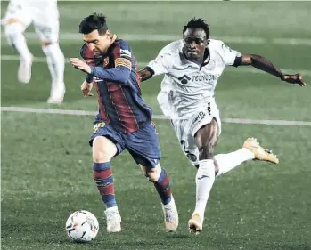  ?? /EFE. ?? Ni el empujón de Djené Ortega (2) detuvo la carrera de Leo Messi (10), quien batió en el mano a mano al portero David Soria para el primero de los cinco goles azulgranas.